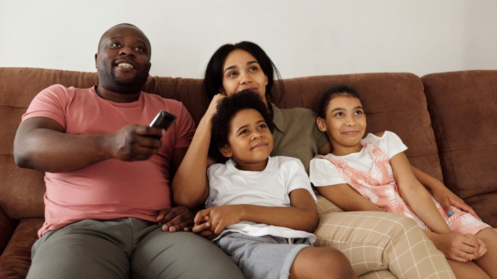Familie samlet i sofaen foran fjernsynet